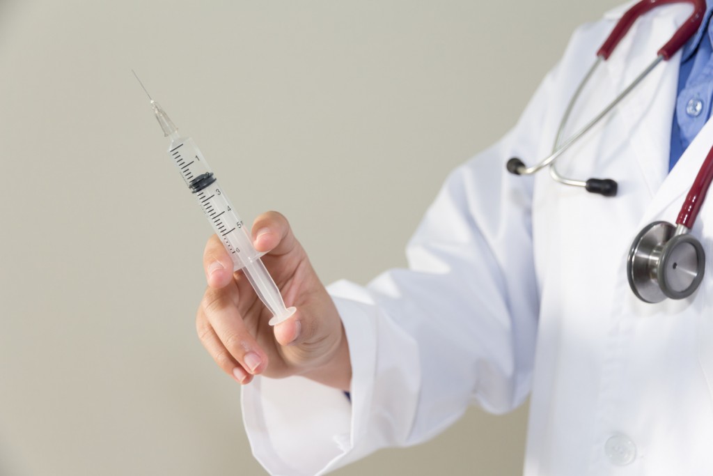 Female doctor  holding syringe with injection concept.