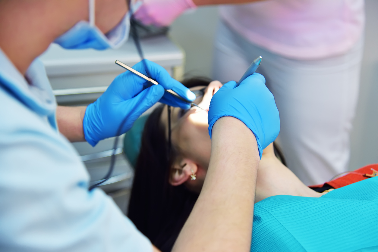 dentist examines the teeth of the young girl