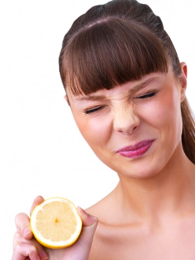 Feeling healthy? Beautiful young girl holding a sour lemon