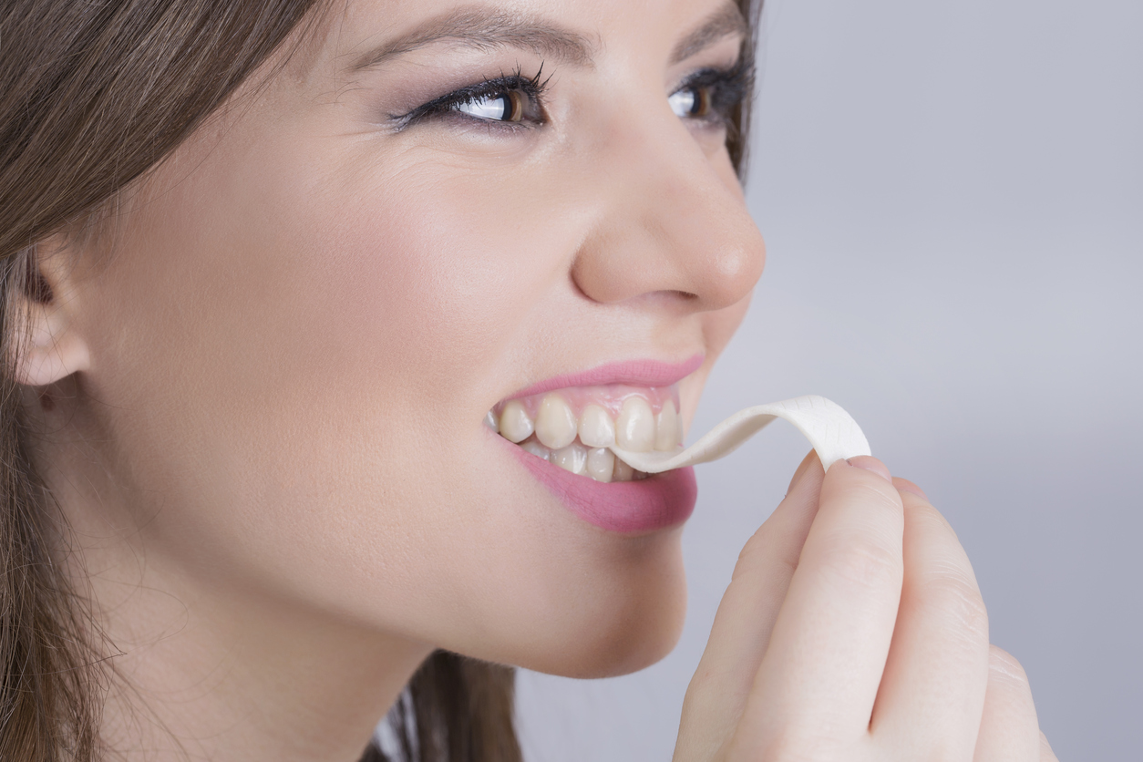 Smiling woman chewing a bubble gum