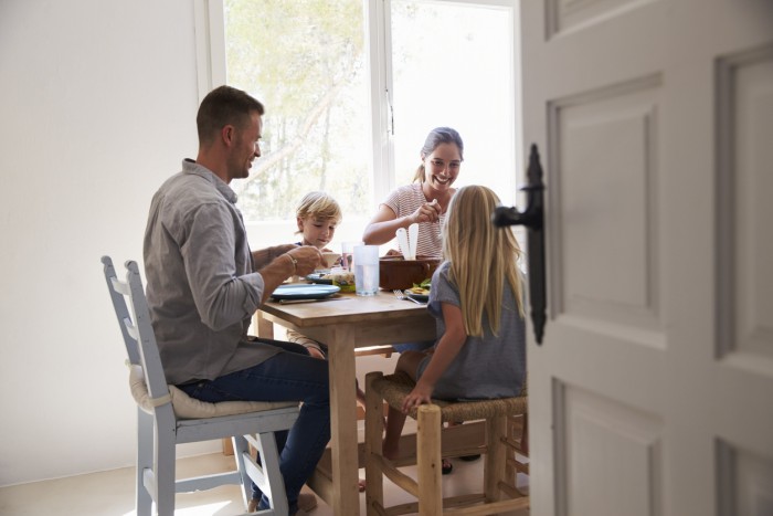 Family eating at table in sunlit room