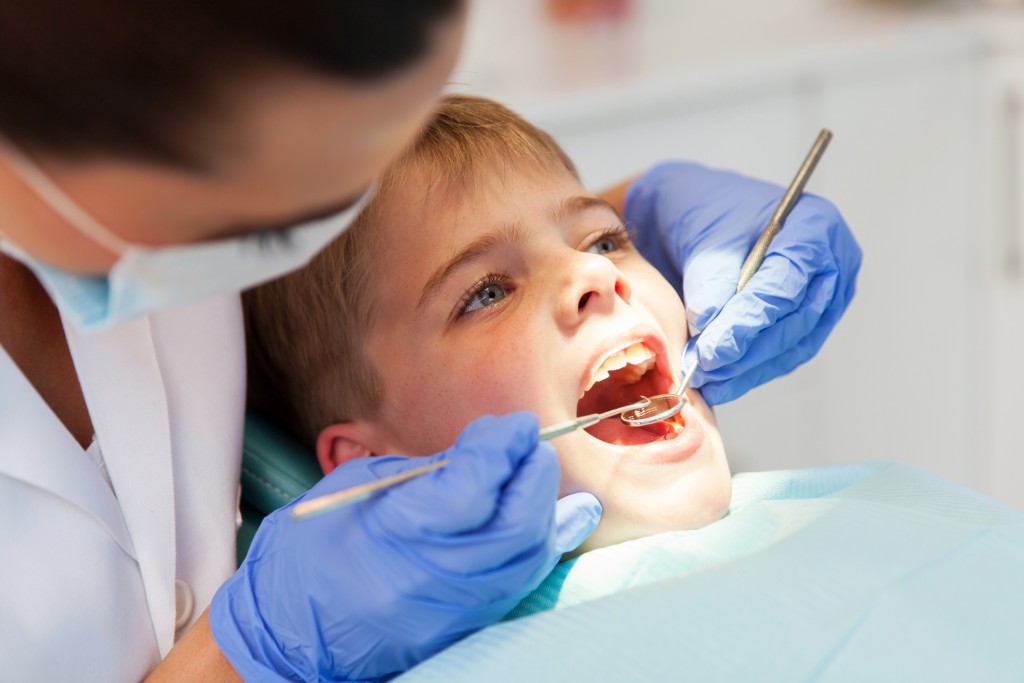 dentist examining boys teeth close up