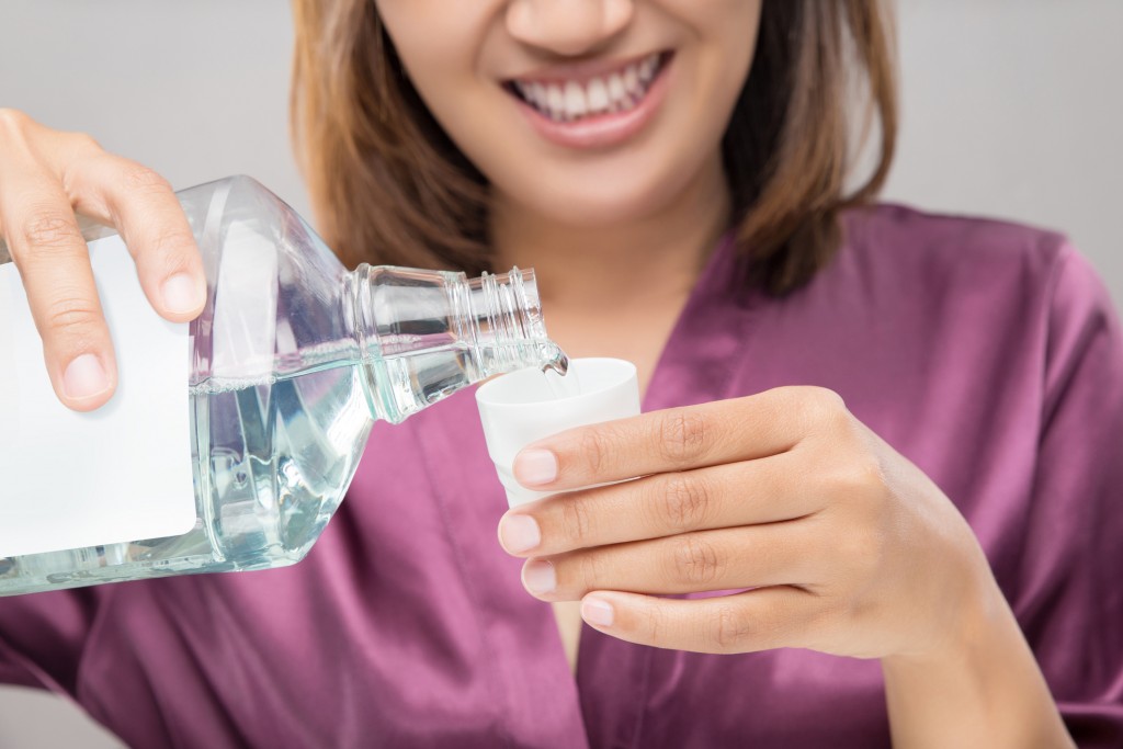 Woman Using Mouthwash After Brushing, Portrait  Hands Pouring Mouthwash Into Bottle Cap, Dental Health Concepts